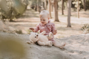 kindje 1 jaar speelt met knuffelbeer